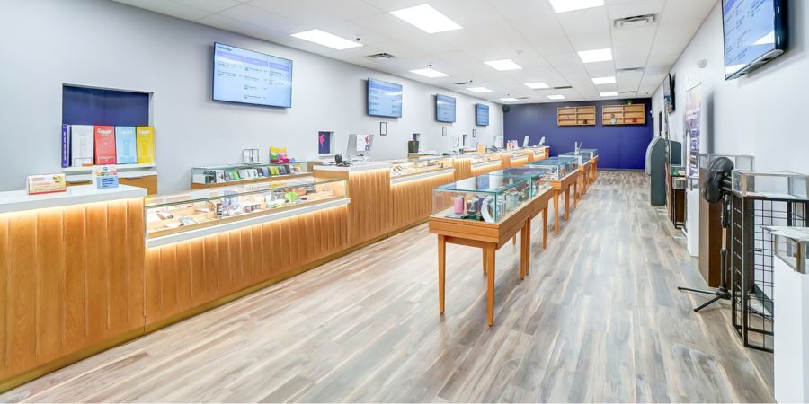 A modern retail store interior with wooden display cases and digital screens on the walls